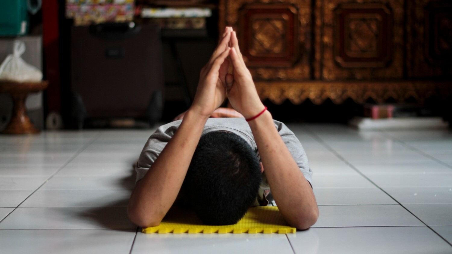 Orang sedang bernamaskara melakukan purifikasi 35 Buddha Pengakuan.