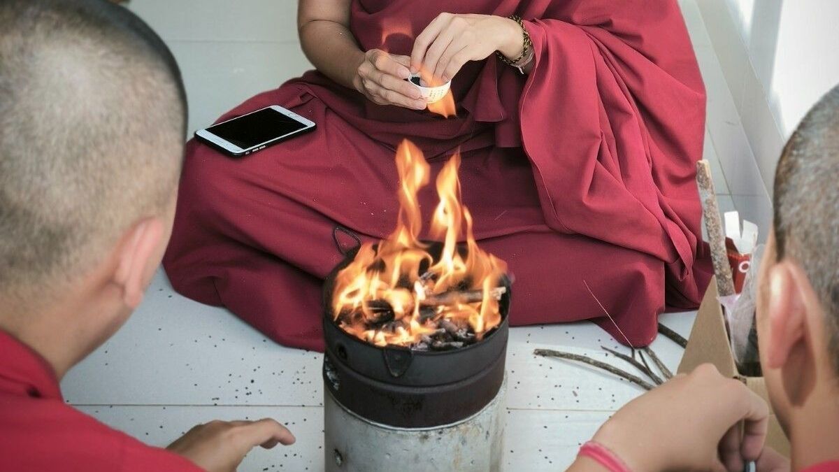 Sangha sedang melempar wijen ke tungku kecil dalam ritual Vajradaka Agnihotra. 